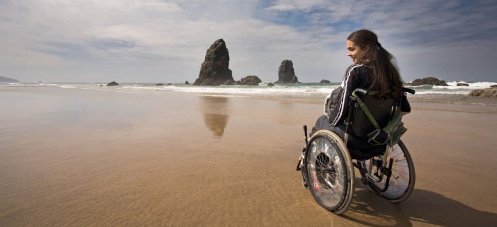 Young women in wheelchair on the beach