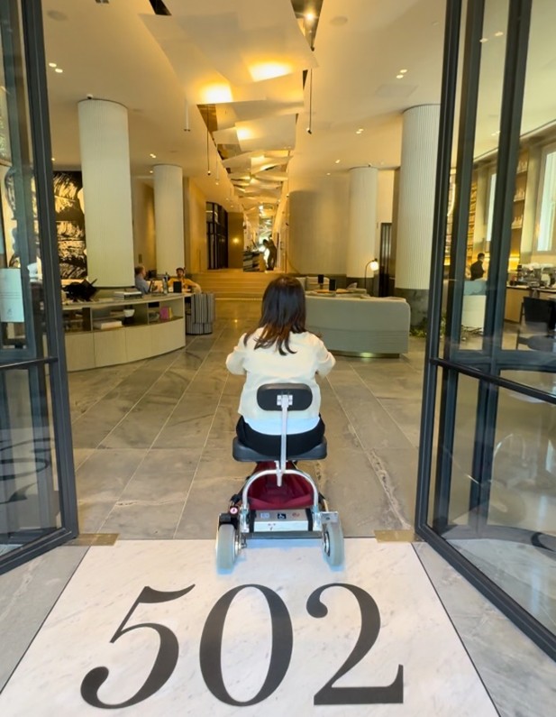 Ash on her mobility scooter using the wide step free entrance to the hotel lobby