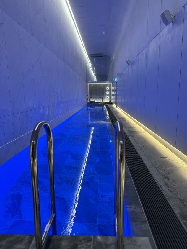 a blue lit indoor swimming pool